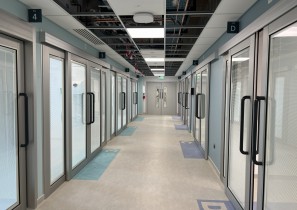 A hospital corridor leading to many assessment rooms.