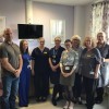 Staff and volunteers gathered together for a group photo in the palliative care room.
