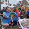 Staff posing with artwork created at the Cultural Awareness Day.