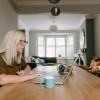 A woman using a laptop at a table in her home.