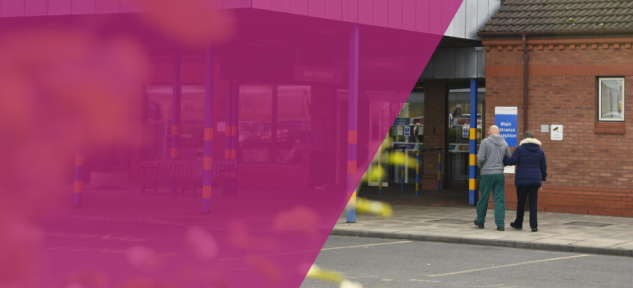 Two people walking into Bridlington Hospital's main entrance.