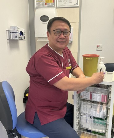 Tim in his work uniform in an office.