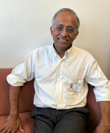 Srinivas Chintapatla sitting on a sofa in an office.