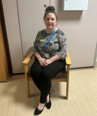 Laura sitting on a chair at work.