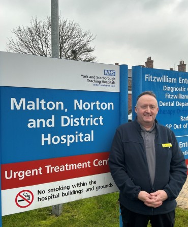 Jezz standing alongside the Malton Hospital sign.