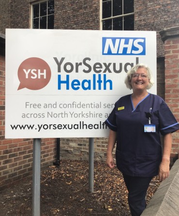 Tanya standing in front of the sign for YorSexual Health.