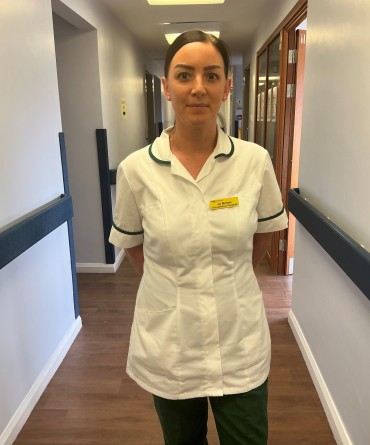 Jo in her OT uniform on a hospital corridor.
