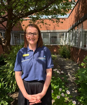 Shannon in a walled hospital courtyard, surrounded by trees casting shade over the scene.