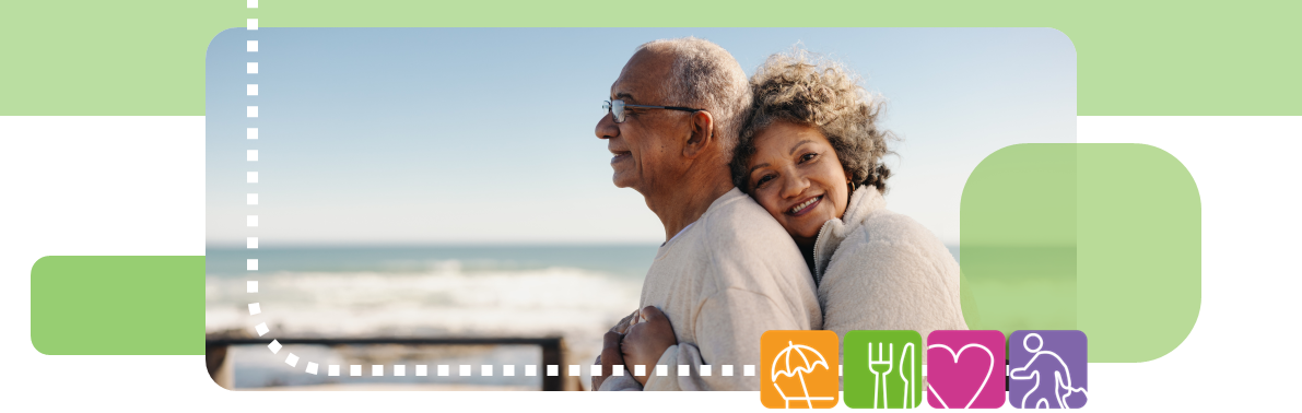 two people, holding each other, stood on beach