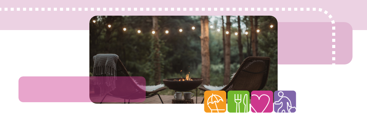 Two empty chairs looking over the view of a forest with fairy lights